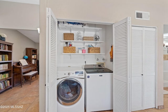 washroom featuring washing machine and clothes dryer and light tile patterned flooring