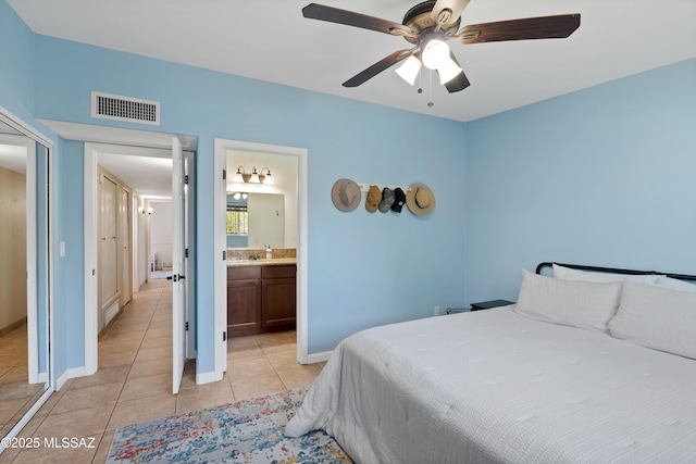 bedroom featuring light tile patterned floors, baseboards, ceiling fan, and connected bathroom