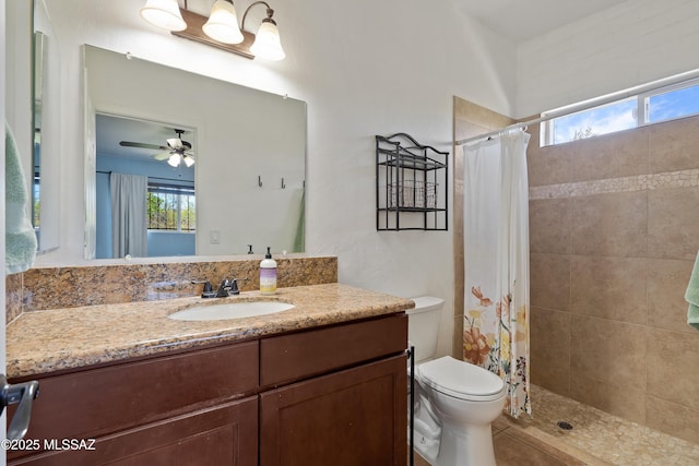 full bathroom with healthy amount of natural light, vanity, toilet, and a tile shower