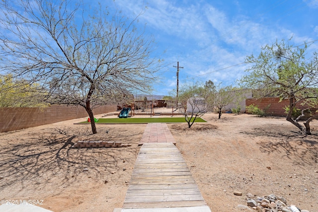 view of yard with a playground and fence