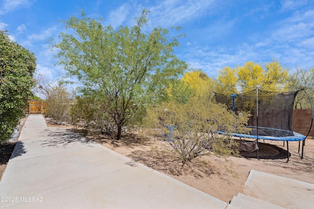 view of yard featuring a trampoline and fence