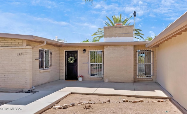doorway to property featuring a patio area and a chimney