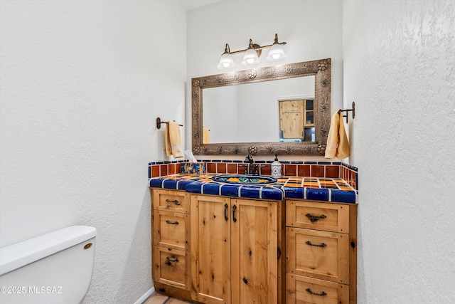 20 Buckskin Ln, Sonoita, AZ 85637 - half bath featuring vanity, a textured wall, backsplash, and toilet
