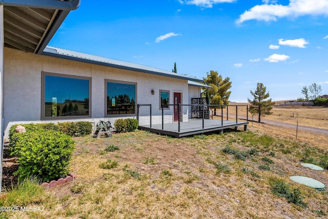 20 Buckskin Ln, Sonoita, AZ 85637 - rear view of house featuring stucco siding, metal roof, a deck, and fence
