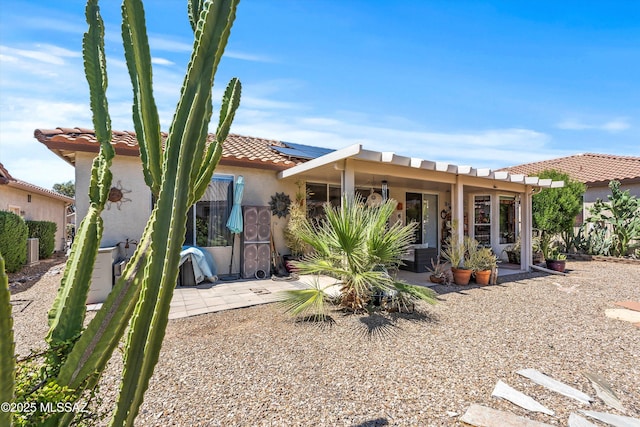 7541 W Wandering Coyote Dr, Tucson, AZ 85743 - back of house featuring a tiled roof, solar panels, a patio, and stucco siding