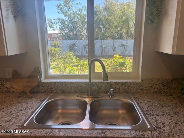 interior details featuring a sink and white cabinetry