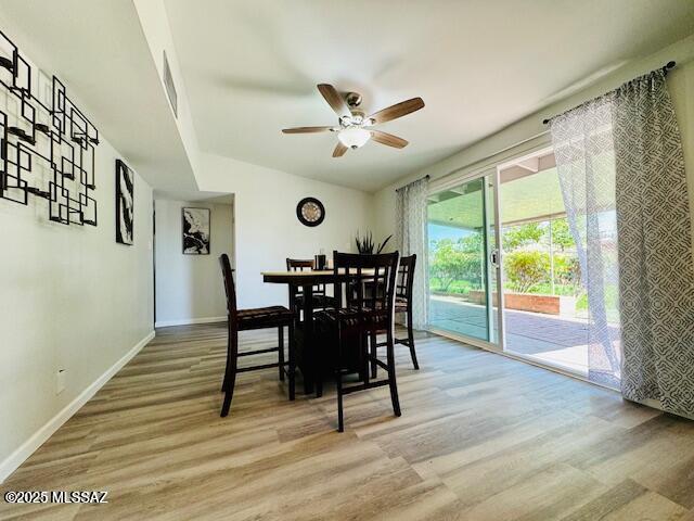 dining area featuring baseboards, a ceiling fan, and wood finished floors