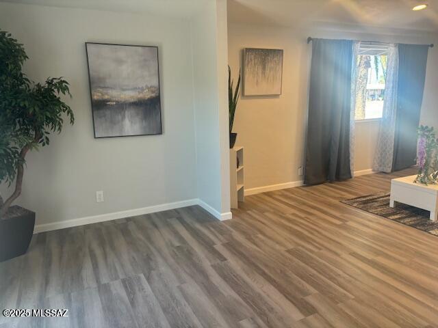 interior space with baseboards and wood finished floors