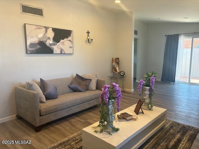 living area with visible vents, baseboards, recessed lighting, and wood finished floors