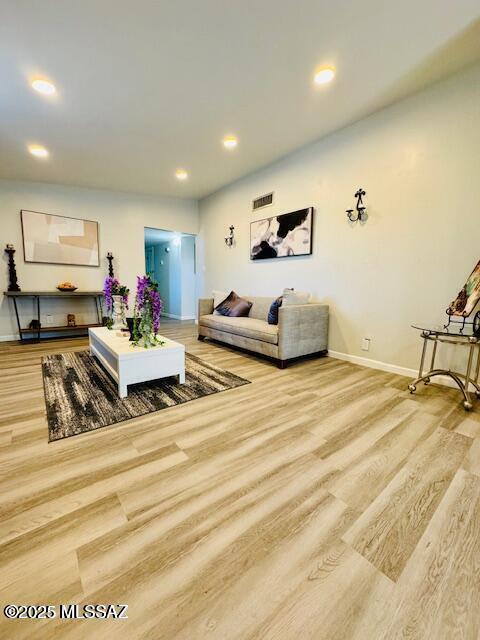 living room featuring recessed lighting, visible vents, baseboards, and wood finished floors