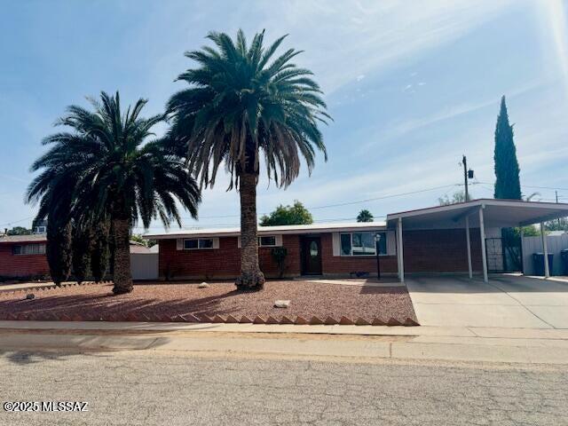 ranch-style home with a carport and driveway