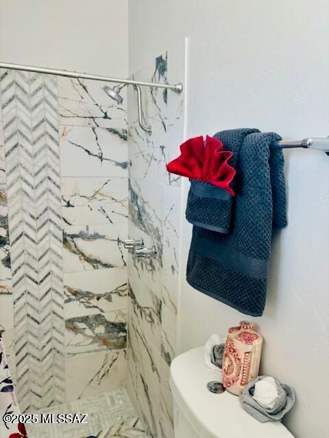 bathroom with a shower stall and toilet