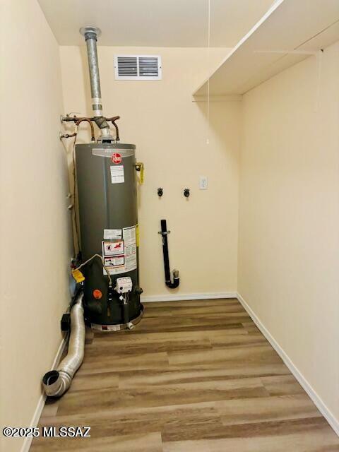 utility room featuring visible vents and water heater