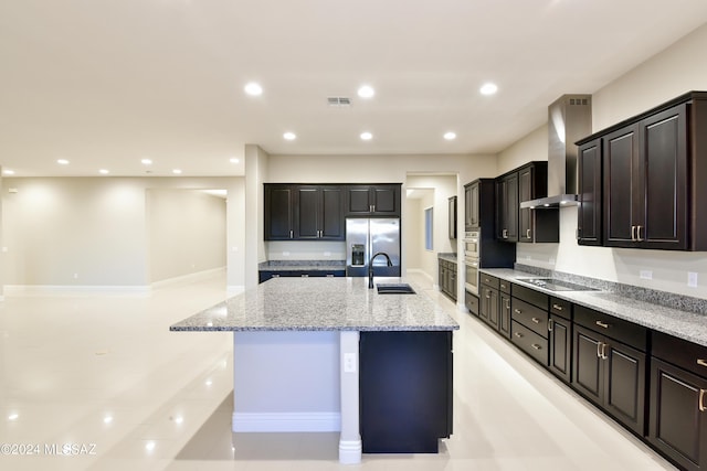 13711 N Hidden Springs Dr, Oro Valley, AZ 85755 - kitchen featuring wall chimney range hood, appliances with stainless steel finishes, a large island, light stone counters, and a sink