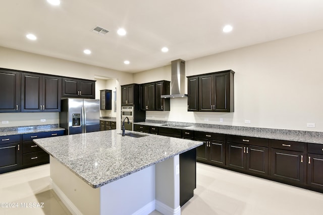 13711 N Hidden Springs Dr, Oro Valley, AZ 85755 - kitchen with appliances with stainless steel finishes, wall chimney exhaust hood, a sink, an island with sink, and light stone counters