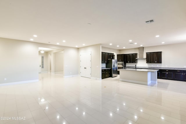 13711 N Hidden Springs Dr, Oro Valley, AZ 85755 - kitchen with open floor plan, wall chimney range hood, appliances with stainless steel finishes, recessed lighting, and an island with sink
