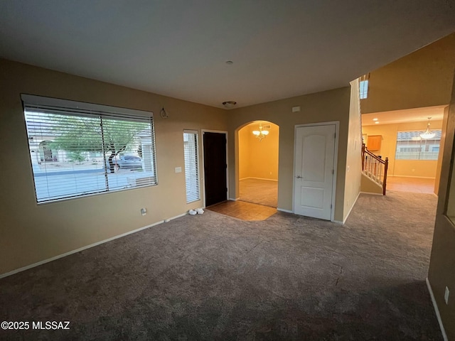 60954 Rock Ledge Loop, Tucson, AZ 85739 - empty room with arched walkways, carpet, baseboards, and stairs