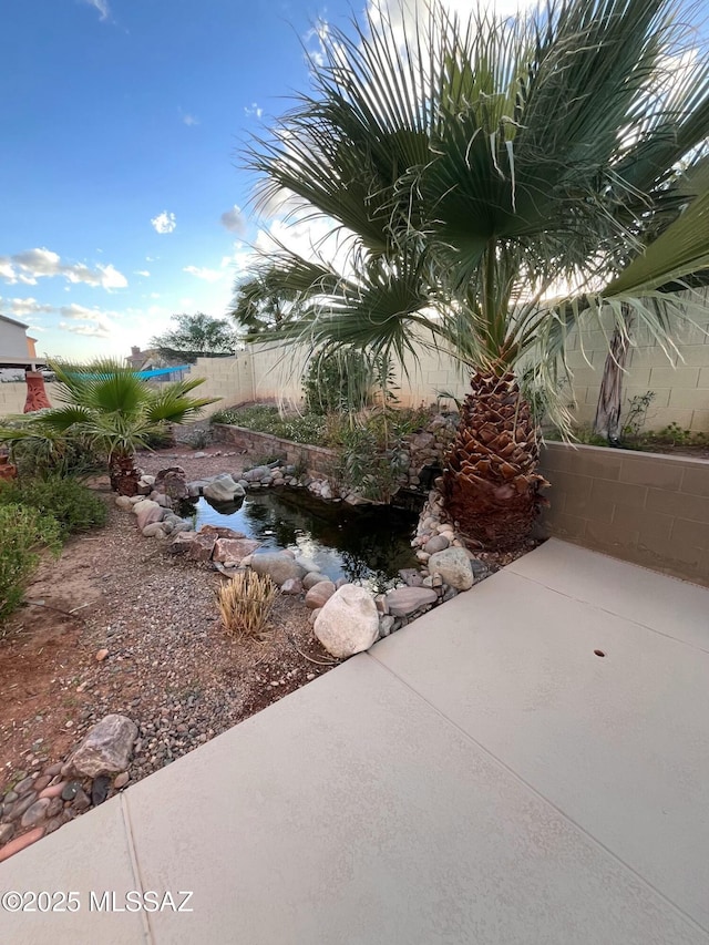 60954 Rock Ledge Loop, Tucson, AZ 85739 - view of yard featuring fence and a small pond