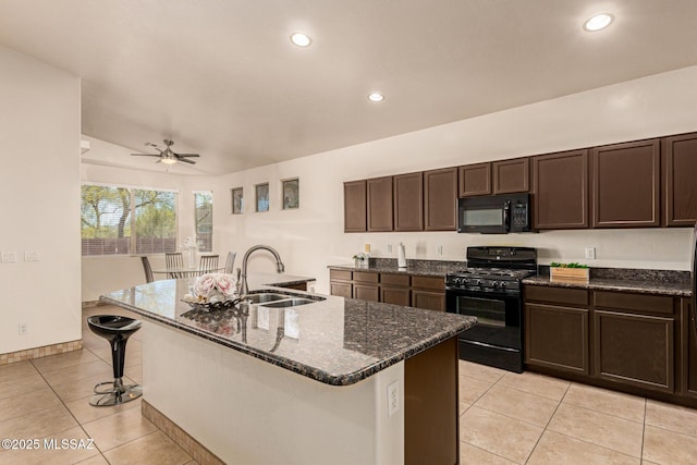 kitchen with a ceiling fan, a sink, black appliances, dark brown cabinetry, and a kitchen bar