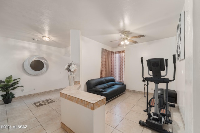 living room with visible vents, a ceiling fan, baseboards, and light tile patterned floors