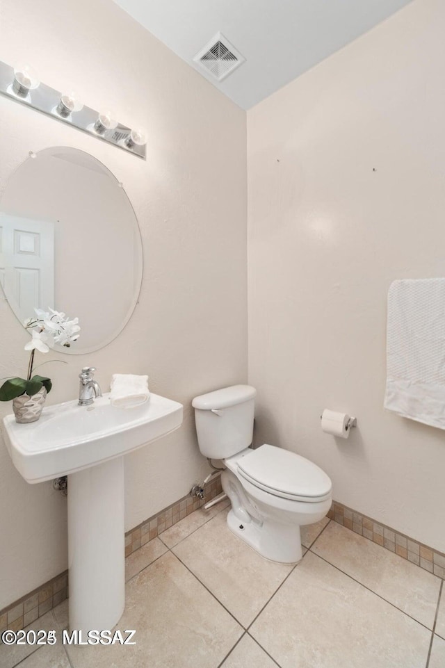 bathroom featuring toilet, tile patterned flooring, visible vents, and baseboards