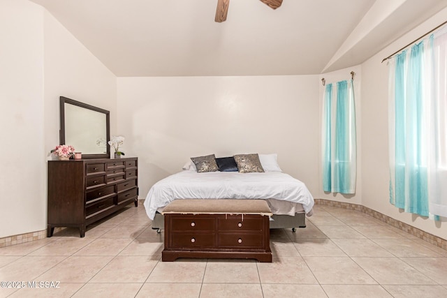 bedroom featuring vaulted ceiling, a ceiling fan, baseboards, and light tile patterned floors