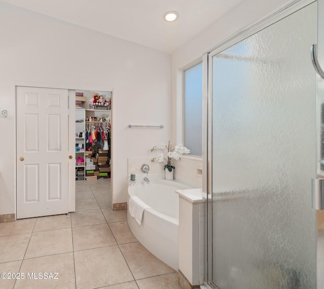 full bath with a bath, tile patterned floors, a spacious closet, recessed lighting, and a shower stall