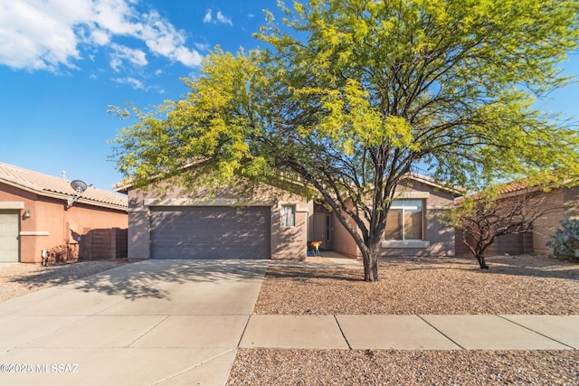 obstructed view of property with stucco siding, driveway, and a garage