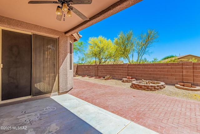 view of patio featuring a fire pit, a fenced backyard, and ceiling fan