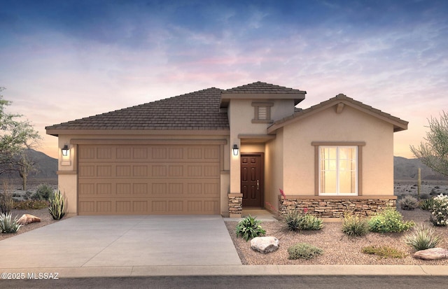 view of front of property featuring a garage, stone siding, stucco siding, a tiled roof, and concrete driveway