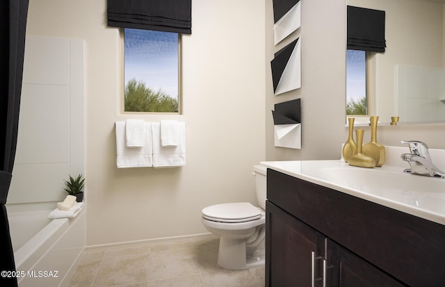 bathroom featuring toilet, baseboards, a tub to relax in, and vanity