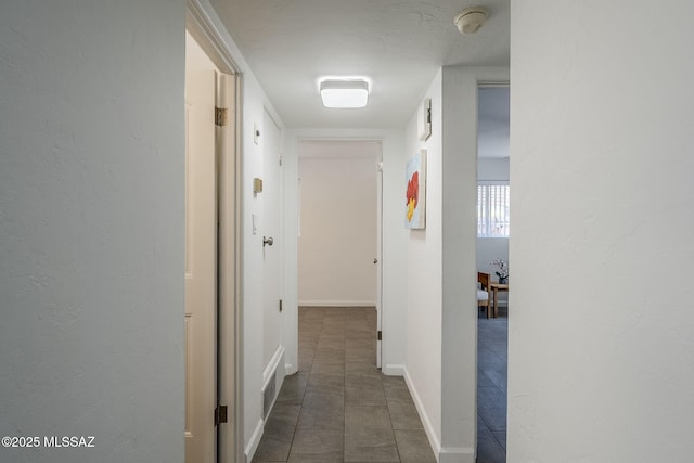 4825 E Hawthorne St, Tucson, AZ 85711 - hallway with dark tile patterned floors and baseboards