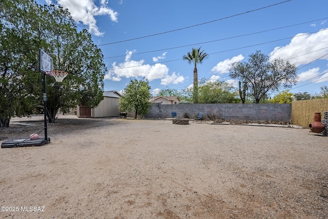 4825 E Hawthorne St, Tucson, AZ 85711 - fenced backyard featuring an outdoor fire pit and a storage shed