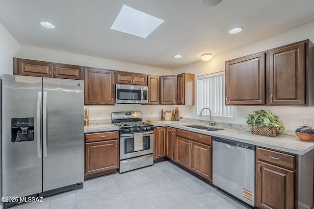 4825 E Hawthorne St, Tucson, AZ 85711 - kitchen with stainless steel appliances, a skylight, light stone counters, light tile patterned flooring, and recessed lighting