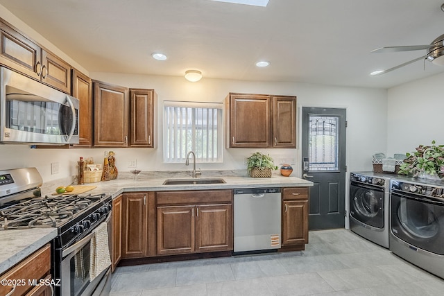 4825 E Hawthorne St, Tucson, AZ 85711 - kitchen featuring appliances with stainless steel finishes, washer and clothes dryer, ceiling fan, light countertops, and brown cabinetry