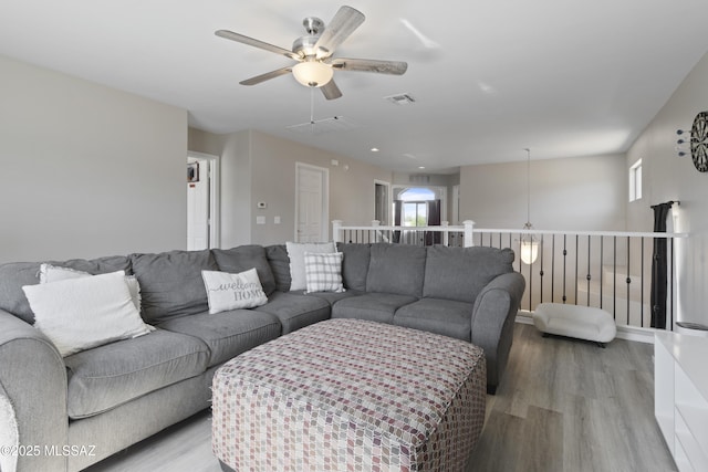 living room with visible vents, a ceiling fan, light wood-style flooring, and a wealth of natural light