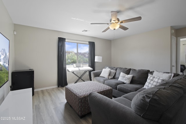 living room featuring baseboards, ceiling fan, light wood-style flooring, and visible vents