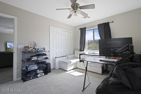 office area with carpet floors, a ceiling fan, and visible vents