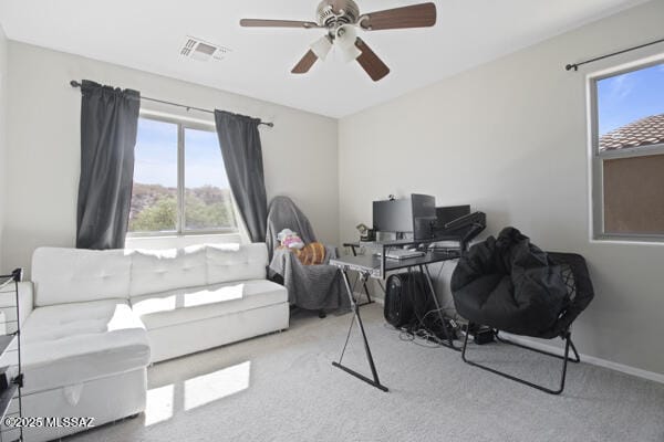 carpeted office featuring visible vents, a ceiling fan, and baseboards