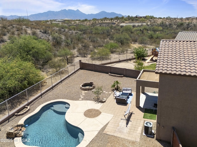 view of pool with a patio, a fenced in pool, a mountain view, and a fenced backyard