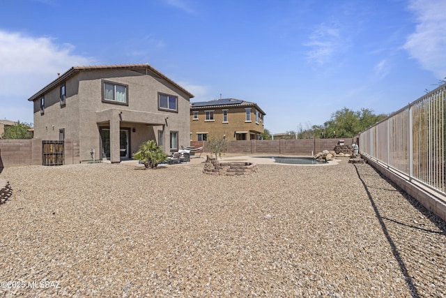 rear view of property featuring a fenced backyard, a patio, and stucco siding
