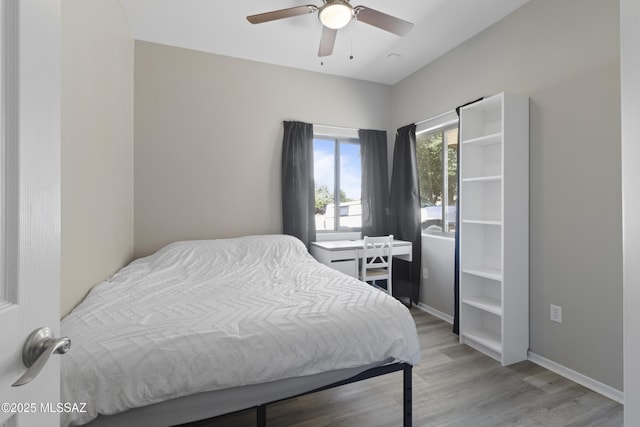 bedroom featuring baseboards, a ceiling fan, and light wood finished floors