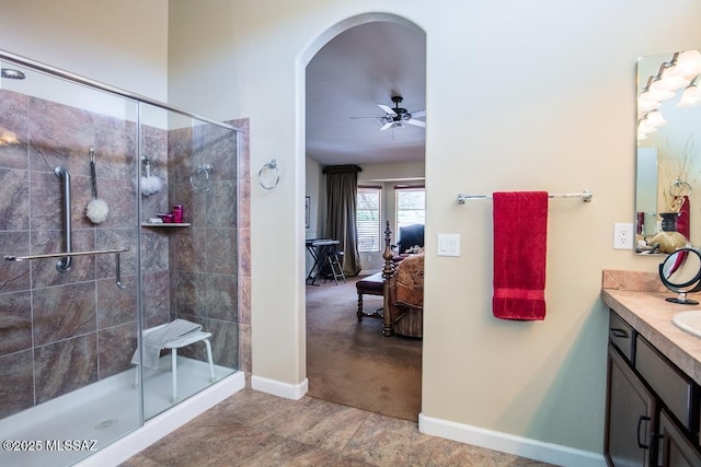 61867 E Ironwood Ln, Tucson, AZ 85739 - ensuite bathroom featuring vanity, baseboards, ensuite bathroom, ceiling fan, and a stall shower