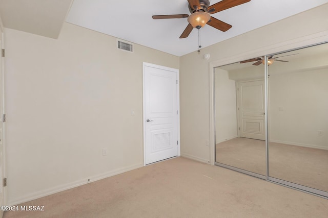 unfurnished bedroom featuring a closet, a ceiling fan, visible vents, light carpet, and baseboards
