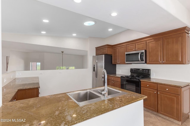 kitchen featuring stone counters, recessed lighting, brown cabinetry, appliances with stainless steel finishes, and a sink