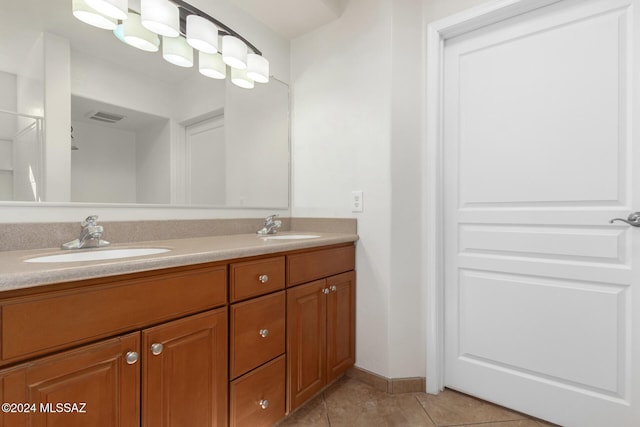 full bath with a sink, visible vents, double vanity, and tile patterned flooring