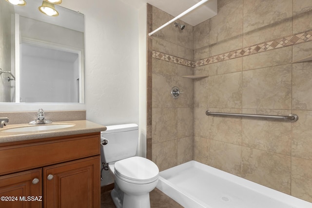 bathroom featuring toilet, a shower stall, and vanity