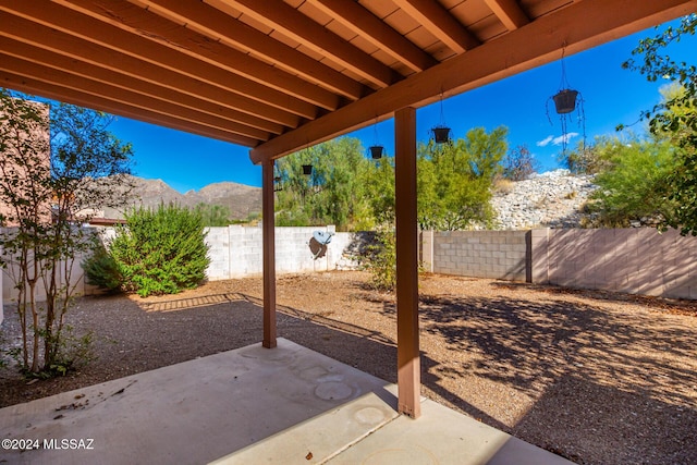 view of patio with a mountain view and a fenced backyard