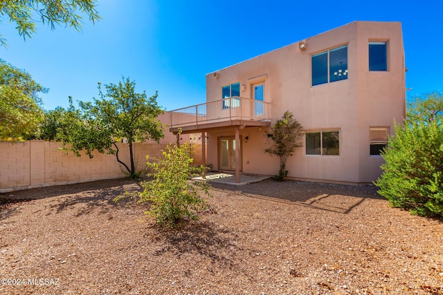 rear view of house featuring a patio area, stucco siding, and fence