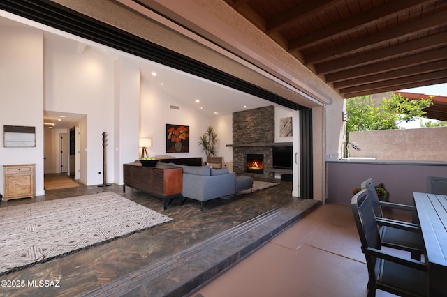 interior space featuring recessed lighting, a stone fireplace, visible vents, and lofted ceiling with beams
